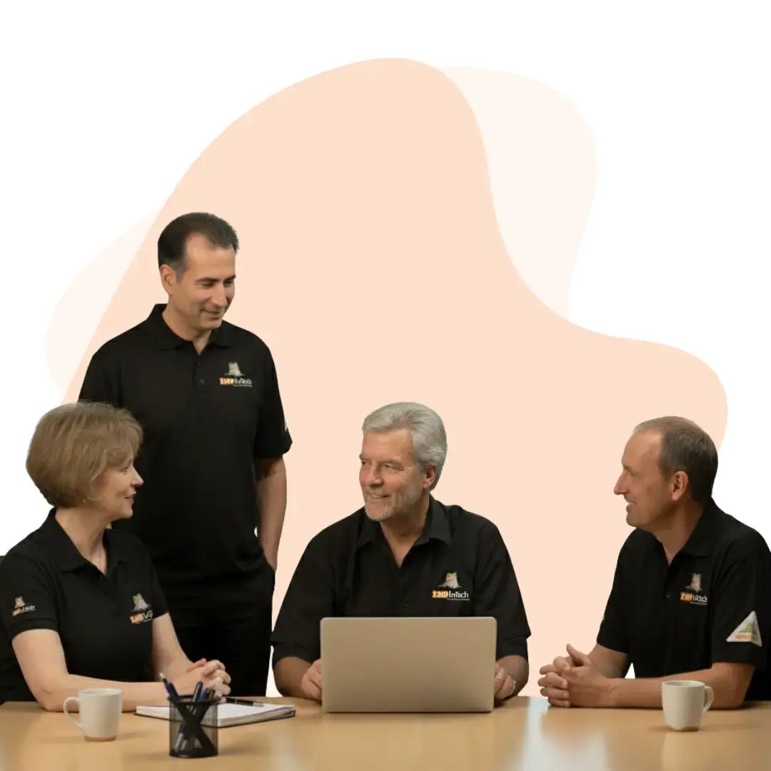 1300 INTECH tech support team reviewing security and performance tasks together on a laptop