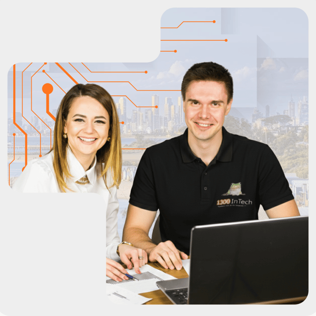 1300 INTECH IT consultant helping a business client with laptop support in a modern office setting