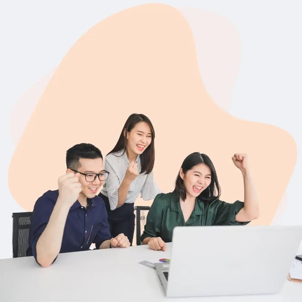 Team celebrating business success during a video conference call, showing collaboration and remote teamwork in a modern office setting